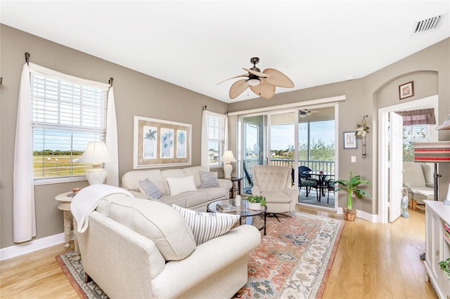 living room with light hardwood / wood-style flooring and ceiling fan