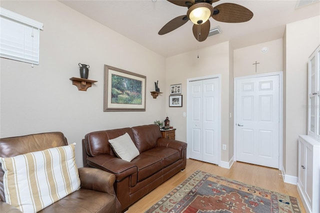 living room with light hardwood / wood-style flooring and ceiling fan