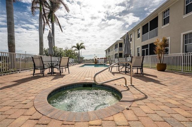 view of pool with a patio area and a hot tub