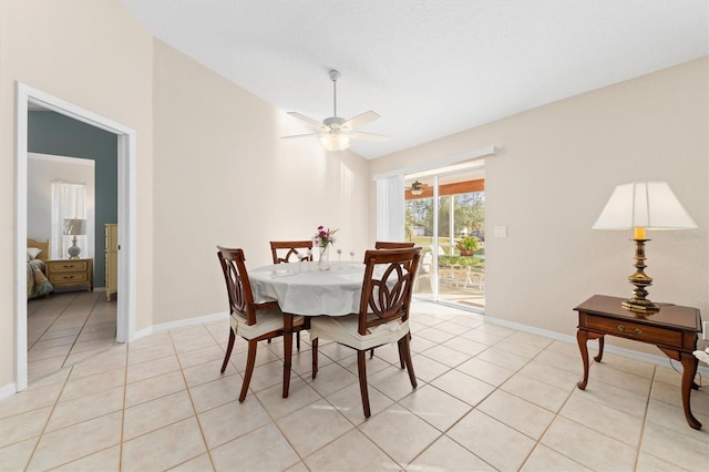 tiled dining area featuring ceiling fan and lofted ceiling