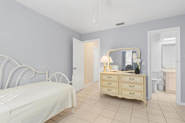 tiled bedroom featuring ensuite bathroom