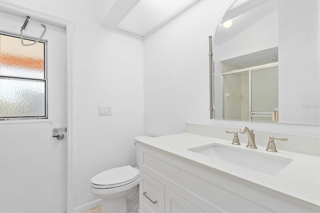 bathroom featuring vanity, toilet, and a shower with door