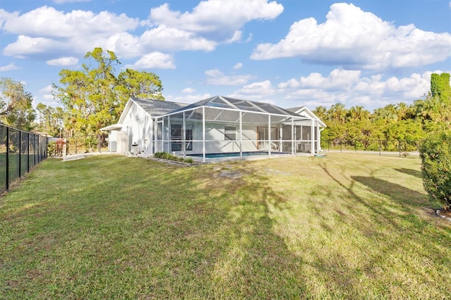 rear view of house with a lanai and a lawn