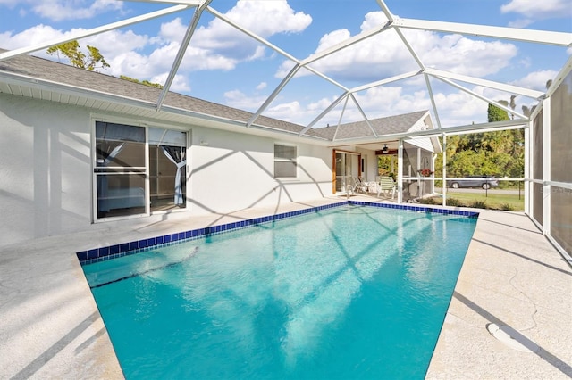 view of swimming pool featuring ceiling fan, a patio, and glass enclosure