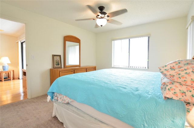 bedroom with ceiling fan and light colored carpet