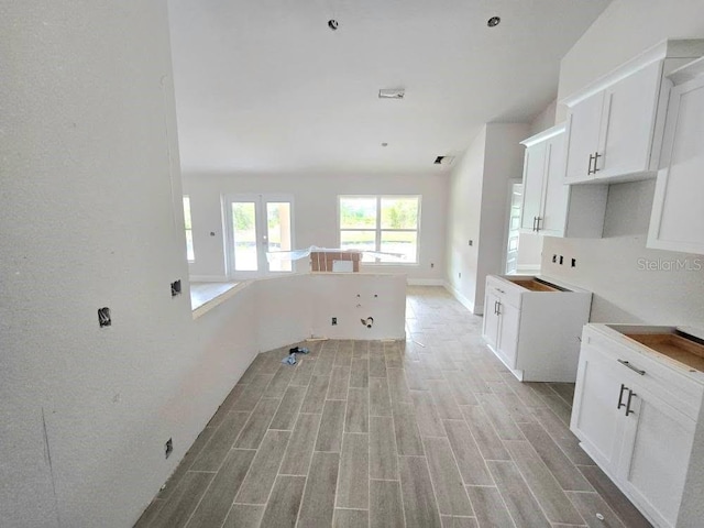 kitchen with open floor plan, visible vents, wood finish floors, and white cabinetry