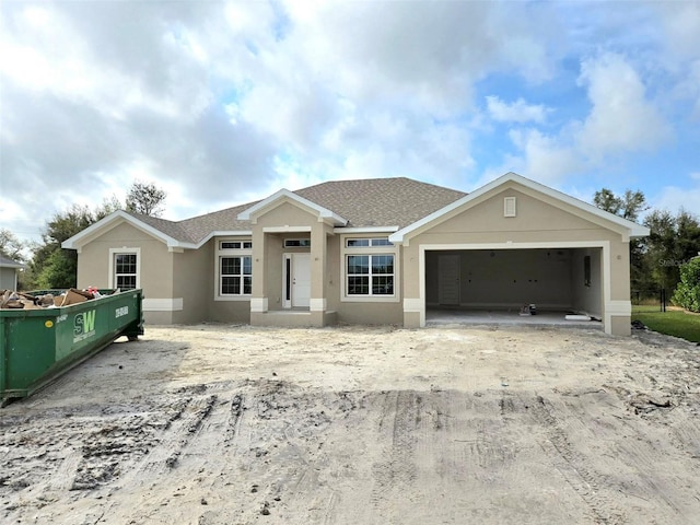 ranch-style home with a garage, roof with shingles, fence, and stucco siding