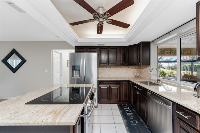 kitchen featuring sink, decorative backsplash, a tray ceiling, light tile patterned flooring, and stainless steel appliances