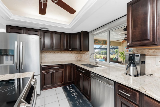 kitchen with backsplash, stainless steel appliances, a tray ceiling, and sink