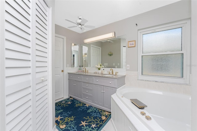 bathroom with vanity, ceiling fan, and tiled tub