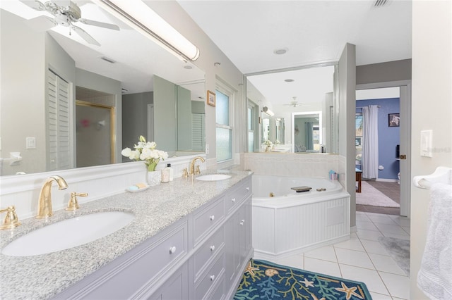 bathroom featuring tile patterned floors, ceiling fan, a washtub, and vanity