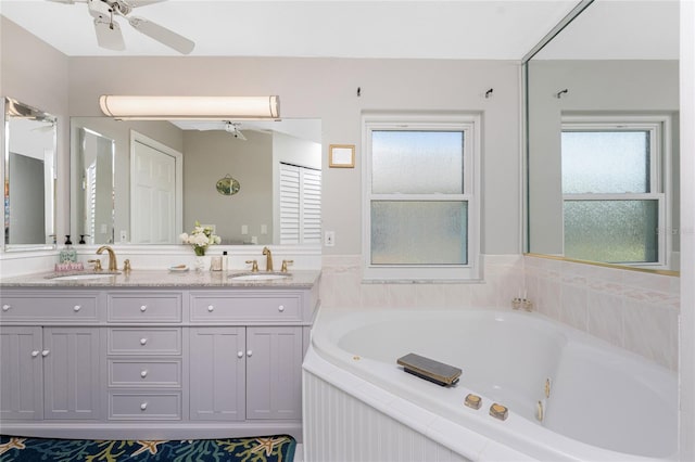 bathroom featuring vanity, ceiling fan, and tiled tub