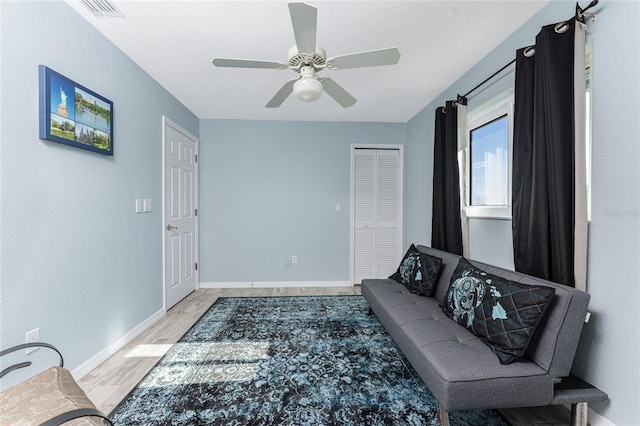 living room with light hardwood / wood-style flooring and ceiling fan