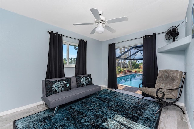 living area with ceiling fan, wood-type flooring, and a pool