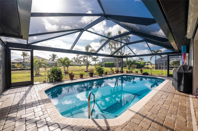 view of swimming pool with a grill, a lanai, and a patio