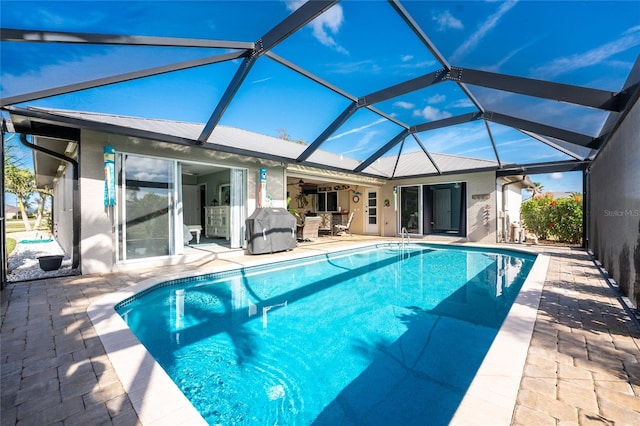 view of pool with a lanai, a patio area, and ceiling fan