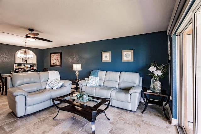 living room with ceiling fan with notable chandelier