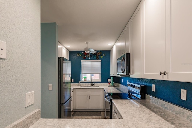 kitchen with ceiling fan, sink, white cabinetry, and stainless steel appliances