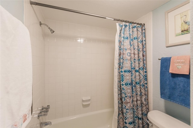 bathroom with shower / bath combination with curtain and toilet