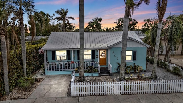 509 W Olympia Ave, Punta Gorda, FL 33950 - view of front of house with covered porch, a metal roof, stucco siding, and a fenced front yard