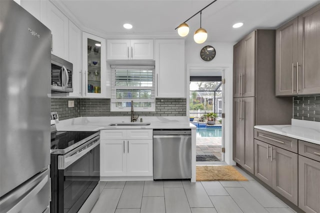 509 W Olympia Ave, Punta Gorda, FL 33950 - kitchen featuring appliances with stainless steel finishes, decorative backsplash, light tile patterned floors, glass insert cabinets, and white cabinets