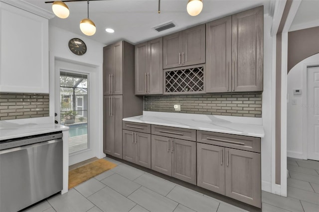 kitchen featuring dishwasher, light tile patterned floors, decorative backsplash, and decorative light fixtures