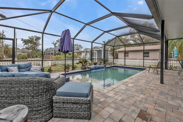 view of pool featuring glass enclosure, pool water feature, outdoor lounge area, and a patio area