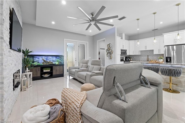 living room featuring ceiling fan, sink, and light tile patterned floors