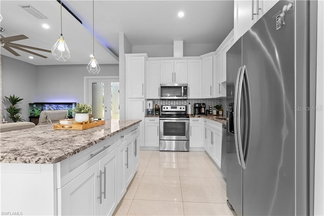 kitchen featuring hanging light fixtures, decorative backsplash, ceiling fan, white cabinetry, and stainless steel appliances