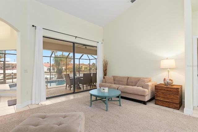 carpeted living room featuring high vaulted ceiling