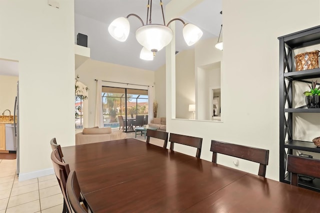 dining room with high vaulted ceiling, a notable chandelier, and light tile patterned flooring