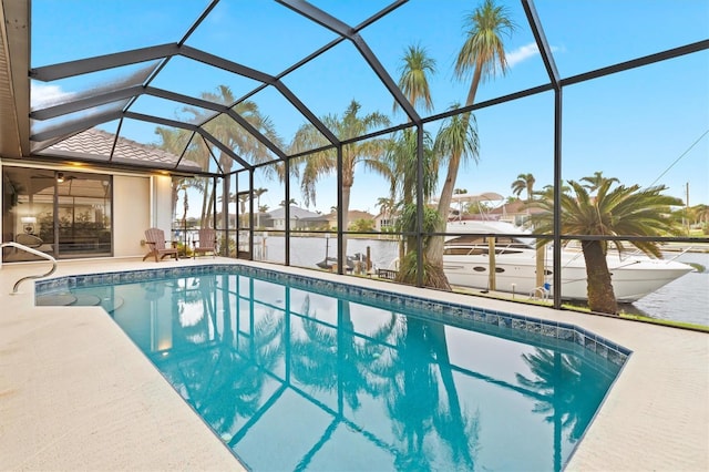 view of swimming pool with a lanai, a water view, and a patio