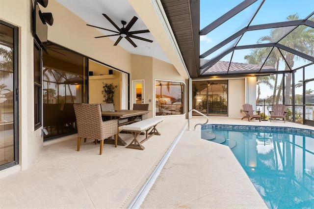 view of swimming pool with a patio, glass enclosure, and ceiling fan