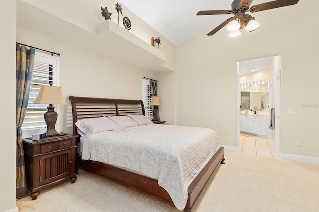 bedroom featuring ceiling fan, lofted ceiling, light carpet, and connected bathroom