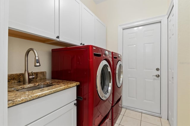 washroom with cabinets, independent washer and dryer, light tile patterned flooring, and sink