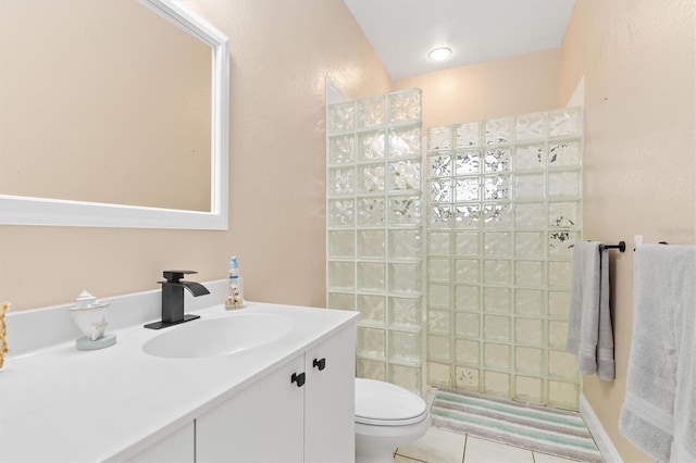 bathroom with tile patterned flooring, vanity, toilet, and walk in shower