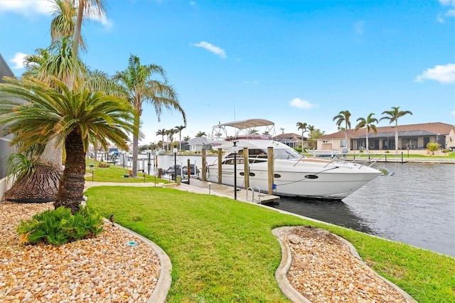 view of dock with a lawn, a water view, boat lift, and a residential view