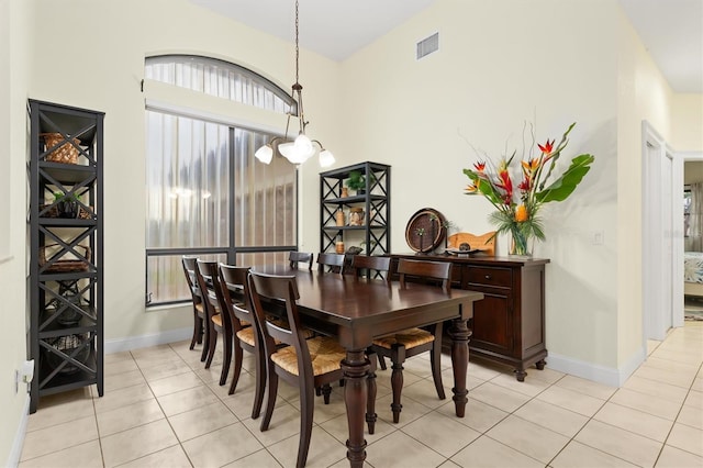 dining area with light tile patterned floors, baseboards, visible vents, and a notable chandelier