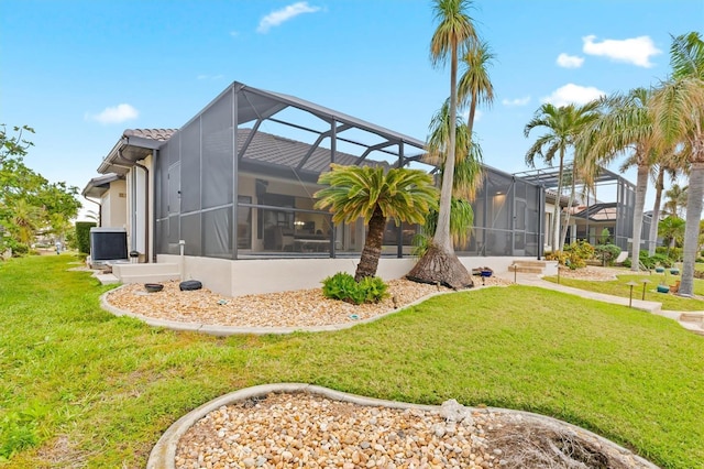 rear view of house featuring a tile roof, central air condition unit, stucco siding, a lawn, and a lanai
