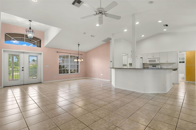 interior space with white cabinetry, light tile patterned floors, pendant lighting, and ceiling fan with notable chandelier