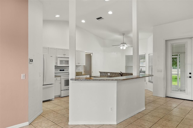 kitchen with white appliances, ceiling fan, light tile patterned floors, high vaulted ceiling, and white cabinetry