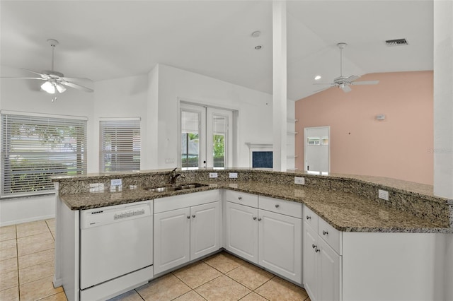 kitchen featuring lofted ceiling, white dishwasher, sink, dark stone countertops, and white cabinetry