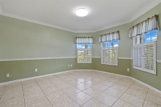 empty room featuring light tile patterned floors and crown molding