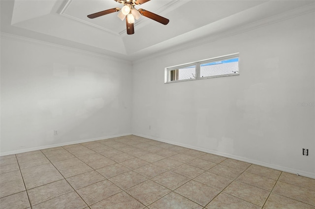 tiled spare room featuring ceiling fan, a raised ceiling, and crown molding