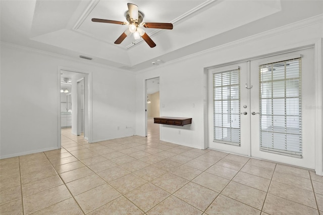 empty room with ceiling fan, french doors, a tray ceiling, light tile patterned flooring, and ornamental molding