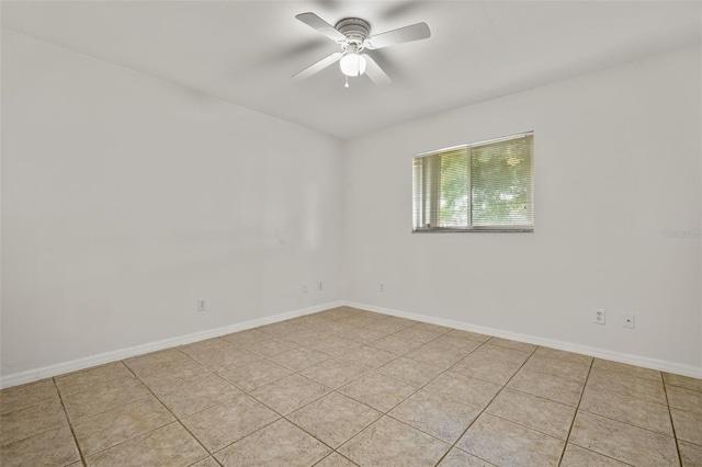 empty room with ceiling fan and light tile patterned floors