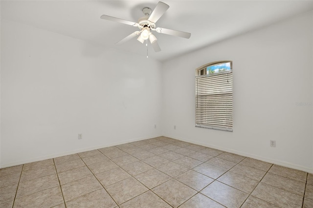 spare room with ceiling fan and light tile patterned floors