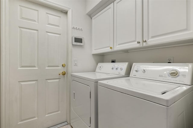 washroom with cabinets and washing machine and clothes dryer