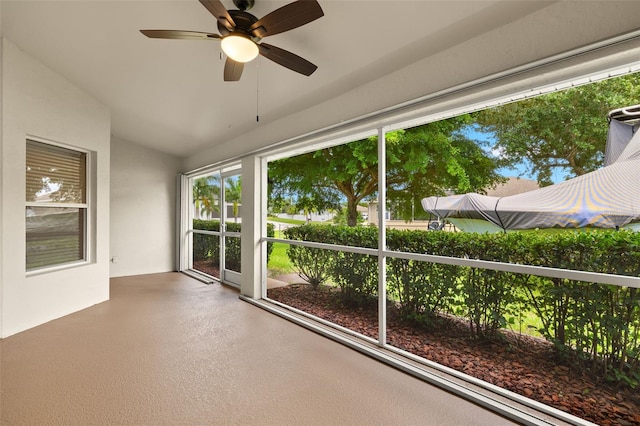 unfurnished sunroom with vaulted ceiling and ceiling fan