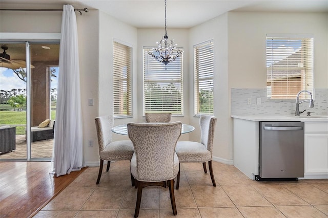 dining area with light tile patterned floors, sink, and an inviting chandelier